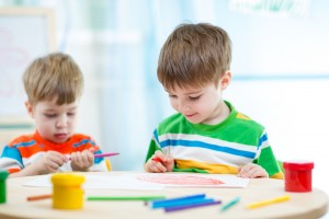 smiling children draw and paint at home or day care center