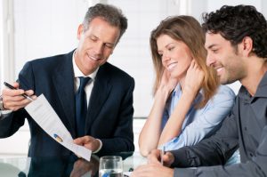 Happy young couple discussing with a financial agent their new investment